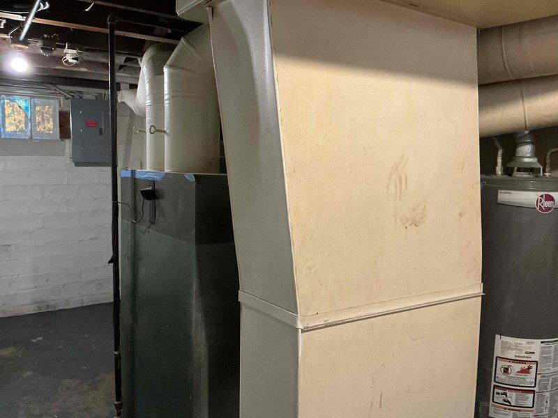 Provided comprehensive estimate for complete HVAC system replacement in residential property. Evaluated existing 1940s-era gravity furnace, assessed current ductwork condition throughout home, and determined requirements for new central air conditioning installation. Documented existing equipment including 86-year-old heating system, photographed mechanical room layout showing furnace, water heater, and existing infrastructure to develop scope of work for full system upgrade including new forced-air furnace, air conditioning unit, and complete duct system replacement.