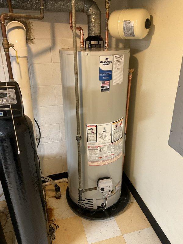 Installed a new 50-gallon Bradford White tanked water heater in basement utility area, replacing existing unit. Completed all necessary code upgrades including proper copper piping connections, expansion tank installation, and appropriate venting system integration. All plumbing connections were secured to manufacturer specifications and system was tested for proper operation upon completion.