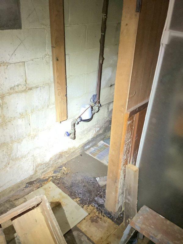 Technician responded to evaluate electrical panel and associated repairs in basement utility area. Upon inspection, found older-style electrical panel with exposed breakers and wiring connections requiring assessment. Panel was mounted on wooden backing board with multiple circuit breakers and various black and gray cables entering from multiple directions. Documented current panel condition and wiring configuration through photographs for repair recommendations. Additionally inspected adjacent utility space with exposed framing and concrete block walls, noting vertical conduit installation secured with mounting brackets. Evaluated overall electrical infrastructure in unfinished basement area to determine necessary repairs and code compliance requirements for panel and associated electrical systems.