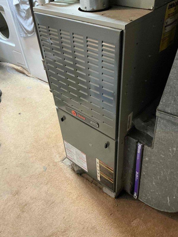 Responded to no cooling complaint on 20-year-old residential HVAC system. Conducted comprehensive system evaluation and documented existing furnace and air conditioning equipment condition. Based on age of equipment, system inefficiency, and repair versus replacement analysis, provided detailed estimate for complete HVAC system replacement including new furnace and air conditioning unit. Photographed existing installation showing furnace cabinet with access panels, ventilation louvers, and associated piping including PVC condensate lines and refrigerant connections in basement mechanical room. Reviewed replacement options and equipment specifications with homeowner.
