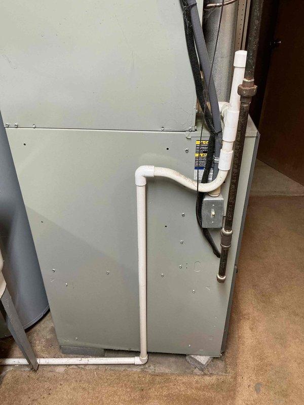 Responded to no cooling complaint on 20-year-old residential HVAC system. Conducted comprehensive system evaluation and documented existing furnace and air conditioning equipment condition. Based on age of equipment, system inefficiency, and repair versus replacement analysis, provided detailed estimate for complete HVAC system replacement including new furnace and air conditioning unit. Photographed existing installation showing furnace cabinet with access panels, ventilation louvers, and associated piping including PVC condensate lines and refrigerant connections in basement mechanical room. Reviewed replacement options and equipment specifications with homeowner.