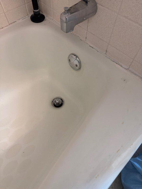 Replaced deteriorated bathtub waste and overflow assembly with new lift-and-turn style unit due to failed gaskets causing intermittent leaking from overflow. Removed existing union-style trap beneath tub and installed permanent glued PVC trap with new trap adapter to eliminate potential leak points and ensure proper drainage. Parts were coordinated through shop for timely completion of repair work.