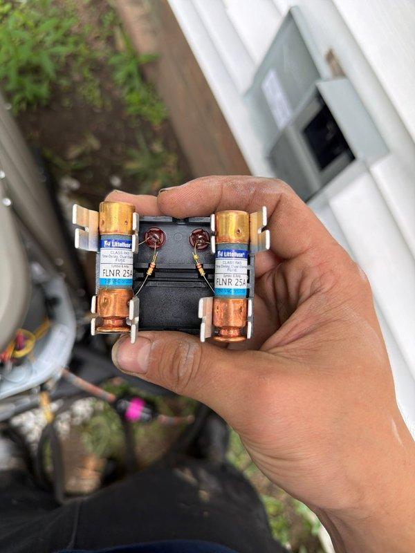 # HVAC Install - A/C & Coil

Successfully completed installation of new air conditioning system with evaporator coil. Installed outdoor condensing unit with proper refrigerant line connections using brass fittings and yellow service valves. Verified electrical connections and installed RNR 25 amp fuses in disconnect block for proper overcurrent protection. Routed flexible refrigerant lines through unit housing with secure connections at service valves. Unit positioned on white rock pad with proper clearances for airflow and service access. All electrical components properly terminated and secured. System ready for startup and commissioning.