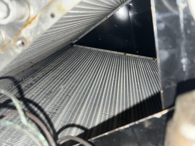 Performed routine maintenance on 13-year-old air conditioning system. Inspected air filter and found it in good condition with minimal debris accumulation. Evaluated evaporator coil and heat exchanger fins, noting some dust buildup but components remain operational. Assessed ductwork for potential cleaning needs and documented system condition with photos for customer records.