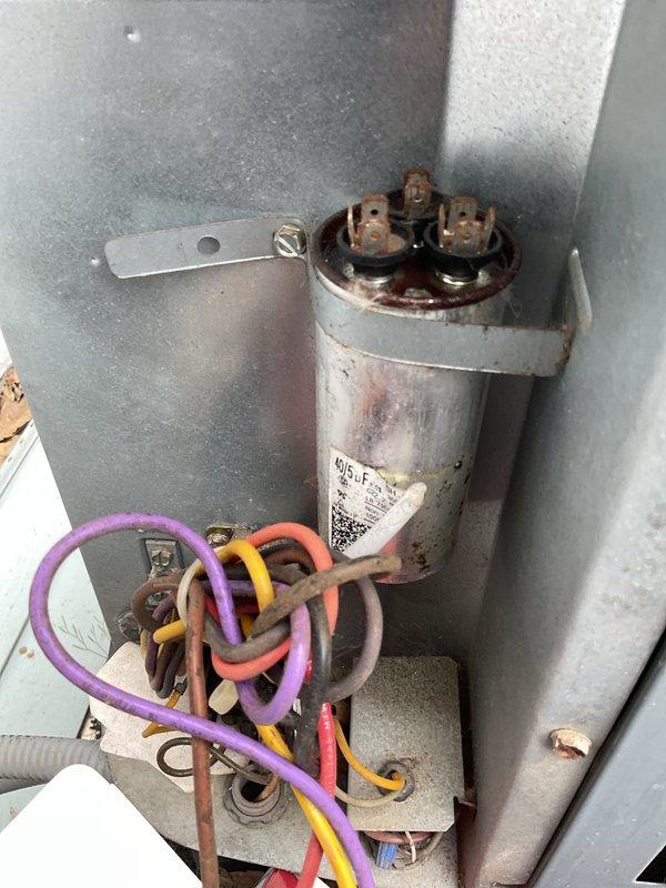 # HVAC Service Completed

Responded to a no-cooling complaint where the air conditioning system was running continuously without producing cool air. Upon inspection, identified a failed dual-run capacitor (Totaline P291-4054RS) showing visible signs of corrosion and deterioration on the terminals and housing. The defective capacitor was preventing the compressor and condenser fan motor from operating at proper capacity, resulting in the system running but failing to cool. Replaced the failed capacitor with a new unit matching the required specifications for voltage and microfarad ratings. Verified all electrical connections at the contactor and terminal blocks were secure. Tested system operation and confirmed compressor and condenser fan motor startup, proper amperage draw, and return to normal cooling function. System now cycling properly and delivering adequate cooling to the conditioned space.