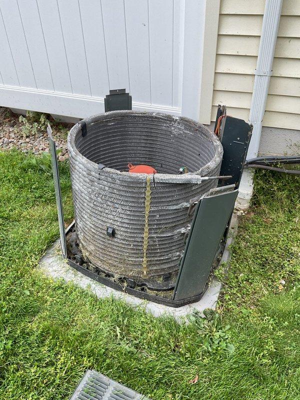 Completed routine cooling maintenance on 12-year-old residential air conditioning system. Inspected outdoor condensing unit with spiral-wound coil housing, noting significant dust and debris accumulation between coil fins consistent with age and outdoor exposure. Cleaned condenser coils to restore optimal heat transfer efficiency. Verified refrigerant lines and connections for proper operation. Measured supply air temperature at 64.2°F, confirming adequate cooling performance. System operational and running within normal parameters upon completion of maintenance service.