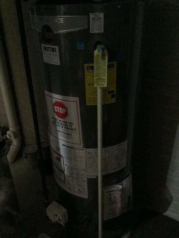 Responded to service call for 5-year-old Rheem natural gas water heater producing only lukewarm water and exhibiting minor leak from bottom of unit. Upon inspection, documented unit condition with photographs showing manufacturer labels, installation information from Jastal Plumbing, and energy guide specifications. Assessed water heater for potential warranty coverage as requested, examining unit age and symptoms to determine eligibility for manufacturer warranty claim. Leak observed at base of tank indicates possible internal tank failure, which would be covered under typical manufacturer warranty terms for a unit of this age.