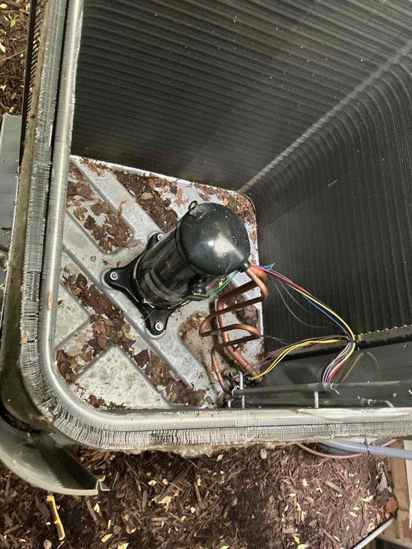 Completed comprehensive AC tune-up on five-year-old central air conditioning system and furnace. Performed standard preventive maintenance protocol including inspection of condenser unit, electrical connections, and refrigerant levels. Observed significant rust and corrosion on motor mounting bracket and accumulation of debris including mulch and organic matter within outdoor unit requiring attention. Documented equipment condition with photographs showing weathered condenser coils, corroded internal components, and vegetation encroachment around unit perimeter. All electrical wiring connections inspected and found secure despite visible corrosion on mounting hardware. System operational at completion of maintenance visit.