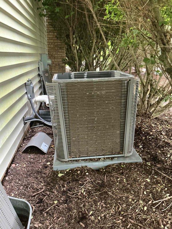 Completed comprehensive AC tune-up on five-year-old central air conditioning system and furnace. Performed standard preventive maintenance protocol including inspection of condenser unit, electrical connections, and refrigerant levels. Observed significant rust and corrosion on motor mounting bracket and accumulation of debris including mulch and organic matter within outdoor unit requiring attention. Documented equipment condition with photographs showing weathered condenser coils, corroded internal components, and vegetation encroachment around unit perimeter. All electrical wiring connections inspected and found secure despite visible corrosion on mounting hardware. System operational at completion of maintenance visit.