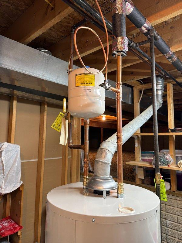 Installed a 40-gallon tall Bradford White water heater with expansion tank in basement utility area. Connected all supply and discharge lines including copper piping, installed 1/2x1/4 shut-off valve, and properly secured expansion tank above unit with copper loop connection. All connections tested and system operational.