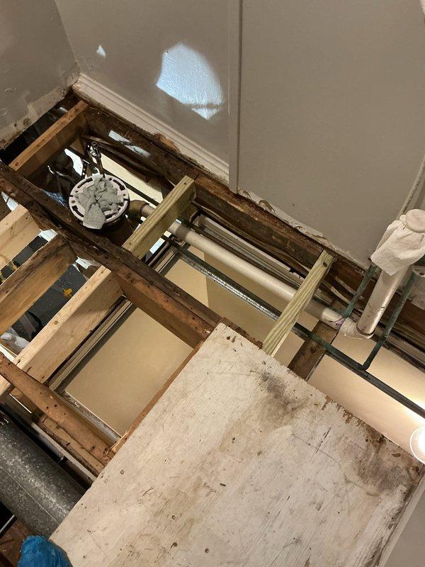 Responded to service call for replacement of deteriorated plumbing infrastructure serving two toilet installations. Upon inspection, found approximately 59-year-old cast iron and copper drain pipes exhibiting severe corrosion and surface deterioration throughout the waste line system. Removed sections of finished flooring to access subfloor plumbing components. Replaced corroded cast iron drain pipes and copper supply lines with code-compliant materials. Removed and replaced two toilet flanges that had deteriorated due to age and corrosion. Work required coordination with existing floor joist structure and HVAC ductwork in confined crawl space area. All replaced components installed to current plumbing code specifications to ensure proper drainage and structural integrity for toilet fixtures.