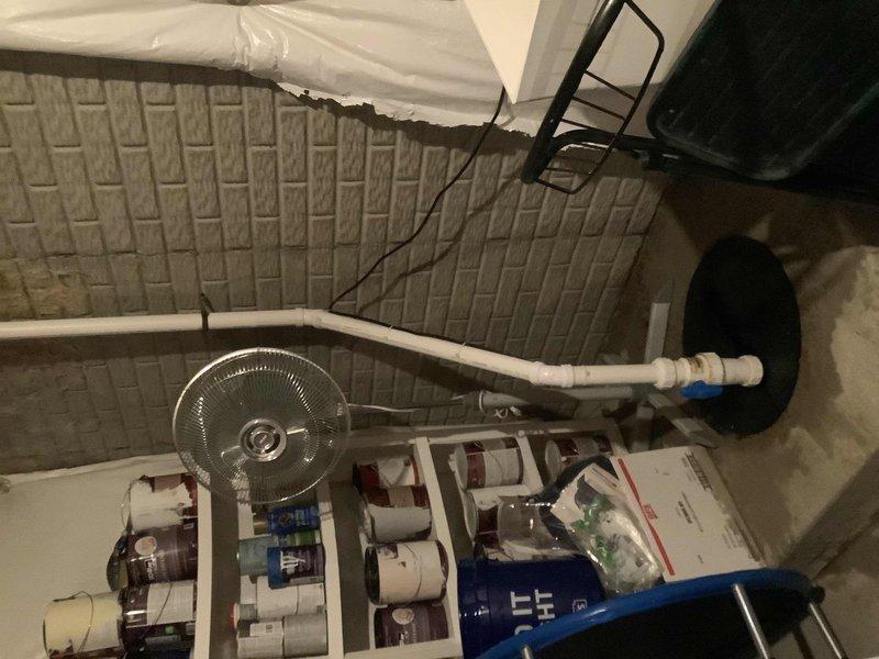 Responded to water leak originating from piping at rear of residence. Upon arrival, conducted thorough inspection of affected area including basement/crawl space where plumbing system was accessible. Located source of leak in PVC piping system running through the structure. Documented existing conditions with photographs showing exposed joists, concrete block walls, and vertical PVC pipe runs. Assessed water damage and placed fan for drying purposes. Completed initial diagnostic evaluation and provided recommendations for repair.