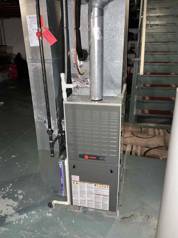 Completed HVAC system replacement estimate for residential property. Assessed existing Trane furnace unit located in basement mechanical room and outdoor air conditioning condenser with cylindrical design positioned on concrete pad with brick paver border. Evaluated current system configuration including gas line connections, refrigerant line set, electrical disconnect, and ductwork routing to provide comprehensive replacement quote for complete heating and cooling system upgrade.