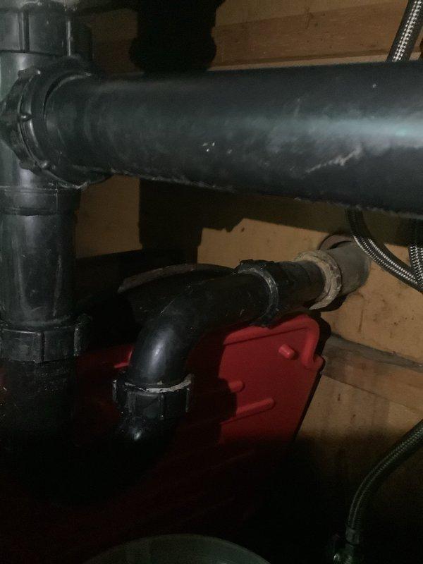 Responded to kitchen sink clog where ceiling had been previously opened to expose plumbing. Upon inspection, accessed drain assembly in basement/crawl space area and identified blockage in drainage system. Cleared obstruction from kitchen sink drain line, verified proper flow through black plastic pipe assembly and connections, and confirmed system was draining properly with no leaks at fittings or joints.
