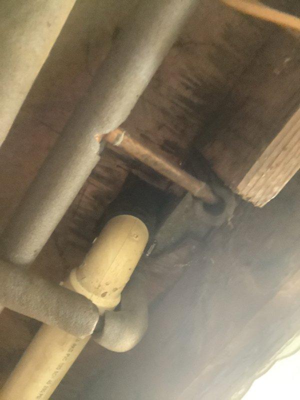 Responded to kitchen sink clog where ceiling had been previously opened to expose plumbing. Upon inspection, accessed drain assembly in basement/crawl space area and identified blockage in drainage system. Cleared obstruction from kitchen sink drain line, verified proper flow through black plastic pipe assembly and connections, and confirmed system was draining properly with no leaks at fittings or joints.