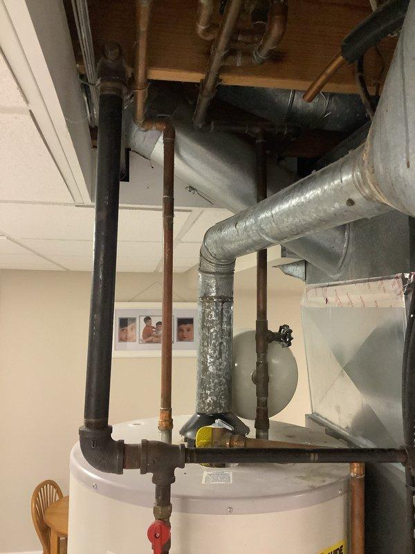 Conducted on-site consultation for new tank-style water heater installation in a 40-year-old residential property. Assessed existing water heater location in finished basement area, noting current configuration with copper supply lines, drainage connections, and proximity to HVAC ductwork. Evaluated mechanical room layout, clearance requirements, and existing plumbing infrastructure to determine optimal installation approach for replacement unit. Documented current equipment setup and surrounding utilities through photographic documentation for accurate equipment sizing and installation planning.