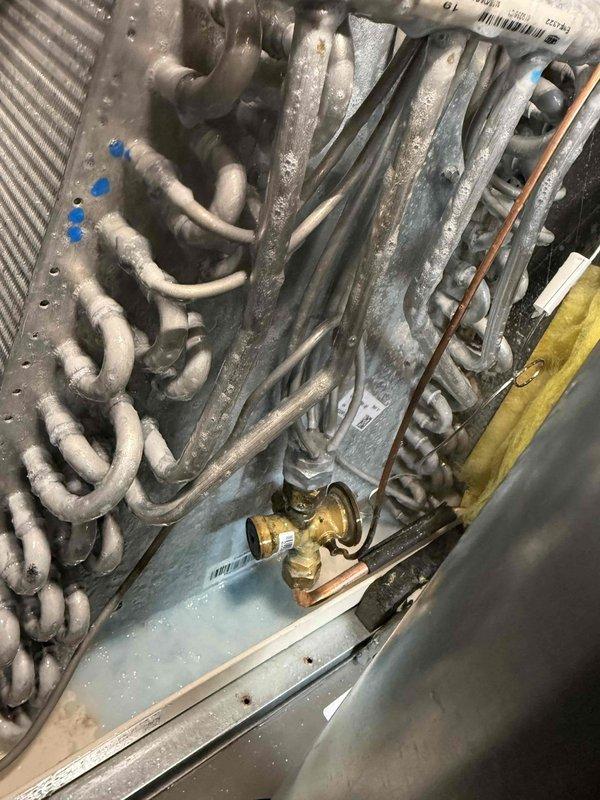 Scheduled to return for warranty leak search on HVAC system when weather conditions reach minimum 70 degrees and dry conditions. Initial inspection completed of indoor evaporator coil assembly and outdoor condenser unit, with photographic documentation of system components including coil configuration, refrigerant lines, and service valves. Estimated 3 hours required for comprehensive leak detection procedure upon return visit under appropriate ambient temperature conditions.