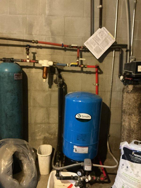 Completed installation of 50-gallon electric water heater in basement mechanical room. Parts were ordered and received in shop, followed by system installation with new water heater kit including all necessary connections to existing copper piping, pressure tank, and expansion tank. All plumbing connections were secured, system was tested for proper operation, and installation was documented with photos showing completed configuration with pressure management equipment and HVAC integration.