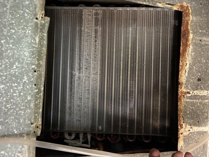 Completed MVP recurring cooling maintenance visit on HVAC system. Performed comprehensive inspection of air handler components including blower wheel assembly and evaporator coil. Blower wheel and motor shaft were found in functional condition with minimal debris accumulation. Noted significant rust and corrosion present along the right edge of the evaporator coil housing frame, which should be monitored for potential future deterioration. All accessible components were visually inspected and photographed for service records. System operating within normal parameters at time of service.