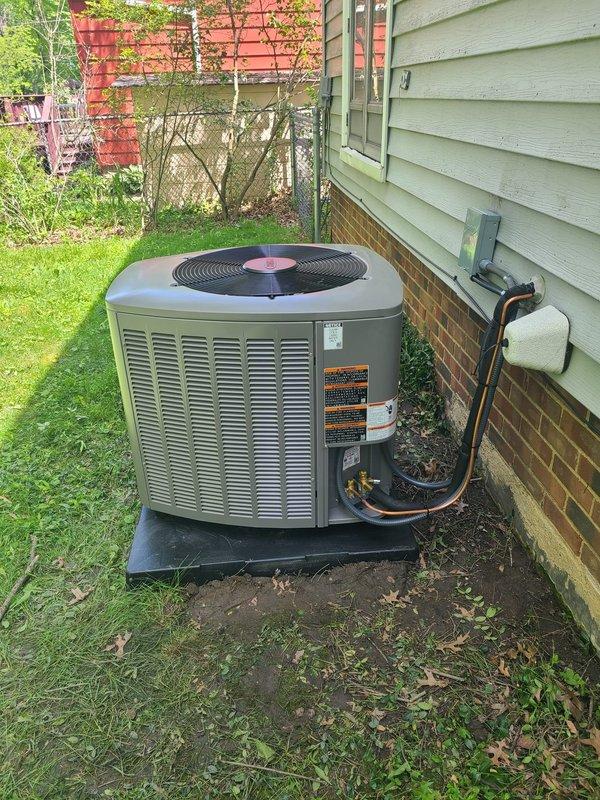 Completed installation of 80% efficiency furnace and air conditioning system. New outdoor condenser unit was positioned on concrete pad against house foundation with proper clearances, connected via insulated refrigerant line set routed up exterior wall. Gas line connections were installed in exterior utility enclosure with dual brass shut-off valves, foam-insulated piping, and copper connecting segments. All equipment secured, labeled, and tested for proper operation.
