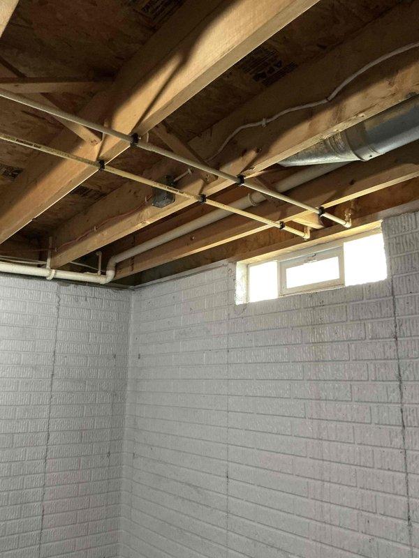 Responded to emergency service call for stolen air conditioning system. Conducted comprehensive site assessment of residential property to provide replacement estimate. Inspected basement area where HVAC equipment connections and ductwork infrastructure remain intact, including existing flexible ductwork and PVC condensate lines visible in floor joist area. Evaluated exterior equipment pad location at building corner near foundation where previous condenser unit was removed. Documented current system configuration and existing infrastructure to determine appropriate replacement equipment specifications and installation requirements.
