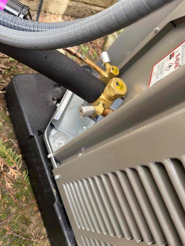 Completed full HVAC system installation including outdoor condensing unit and indoor air handler with evaporator coil. Installed new condensing unit on protective base pad with proper refrigerant line connections using insulated copper linesets—gray insulation on liquid line and black foam on suction line. Mounted air handler unit in basement utility area against block wall, established proper condensate drainage using white PVC piping with appropriate fittings routed to floor drain. Connected all refrigerant lines to both indoor and outdoor units using brass service valves, completed electrical connections, and verified all manufacturer specifications and warning labels are properly affixed to equipment. System installed per code requirements and manufacturer guidelines.