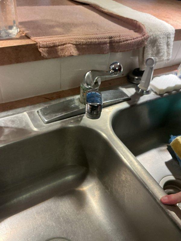 Responded to service call for multiple plumbing issues including sump pump discharge pipe leak, leaking kitchen and bathroom faucets, and faucet installation request. Upon inspection, assessed the sump pump discharge connection for source of leak and evaluated condition of kitchen double-basin sink faucet and bathroom sink faucet, both showing signs of wear and active leaking. Documented existing fixtures with photos showing chrome kitchen faucet with spray attachment and two-handle chrome bathroom faucet. Provided recommendations for repair or replacement of leaking fixtures and discussed faucet installation in additional bathroom using customer-supplied parts.