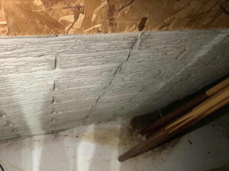 Responded to service call for reported leak from rear faucet causing water intrusion into basement area. Upon arrival, conducted thorough inspection of kitchen sink plumbing system and underlying basement structure. Examined under-sink cabinet installation including PVC drain assembly, P-trap configuration, garbage disposal unit, and flexible water supply lines. Inspected basement ceiling area directly below kitchen plumbing, identifying moisture evidence on painted wooden joist with visible stress crack and copper supply line routing. Assessed all connection points, drain components, and supply line fittings for signs of active leakage or moisture accumulation. Documented plumbing configuration and structural conditions with photographic evidence for service records.