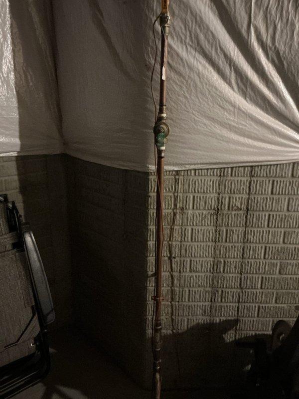 Conducted free estimate for automatic water shut-off valve installation in basement utility area. Assessed existing copper water supply line with green valve fitting and documented current plumbing configuration for potential valve upgrade under campaign availability.