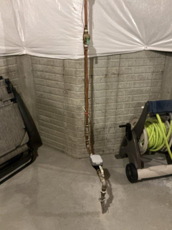 Conducted free estimate for automatic water shut-off valve installation in basement utility area. Assessed existing copper water supply line with green valve fitting and documented current plumbing configuration for potential valve upgrade under campaign availability.