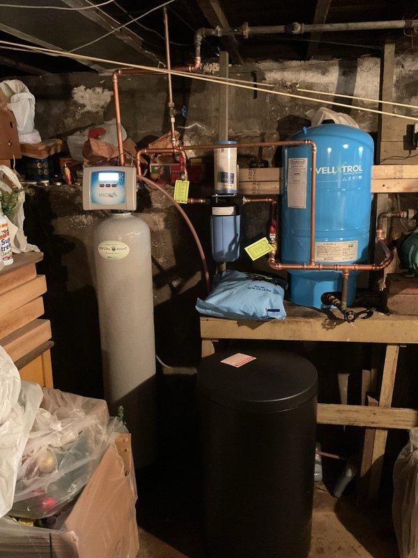 Installed complete water treatment system for well water with iron content below 2.5-3 ppm. System includes wall-mounted iron filter with pre and post isolation valves, metered water softener equipped with 2510 mechanical control head and bypass valve assembly, and upgraded brine tank with grid system. All components connected via copper piping to existing well pressure tank system. System sanitized, tested, and commissioned. Salt supply provided and system staged for operation.