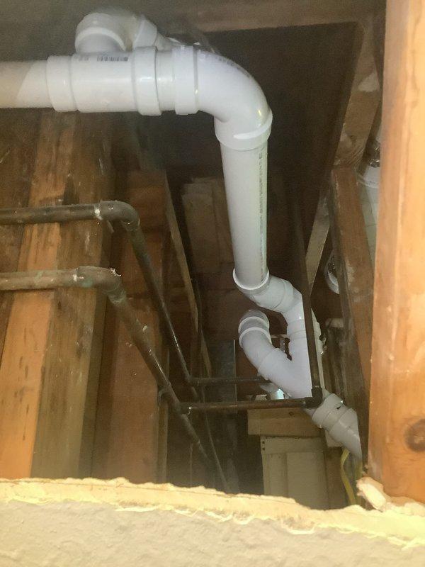 Responded to failed plumbing inspection due to venting code violations for shower and tub installations not meeting 2024 Ohio plumbing code requirements. Removed all existing cast iron piping from basement through second floor of split-level home servicing both bathrooms. Rebuilt complete drainage stack system installing new waste and overflow assemblies for both bathrooms, new P-traps for both toilets and lavatories, and ran new Schedule 40 PVC stack to basement with cleanout access. All piping properly secured to structural framing members with metal fastening straps and configured with appropriate elbow joints for proper drainage and venting throughout the system.