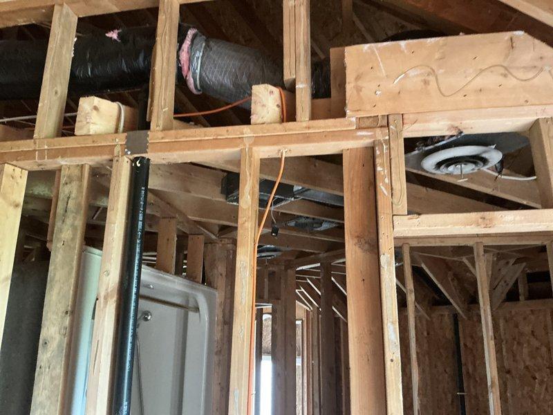 Conducted comprehensive estimate for complete HVAC system replacement following fire damage to residential property. Assessed existing flexible ductwork in ceiling joists showing heat damage and compromised insulation, evaluated wall-mounted Honeywell Home ProSeries thermostat for replacement compatibility, and documented extensive structural exposure requiring new furnace, air conditioning unit, and complete ductwork installation throughout affected areas with coordination of electrical components.