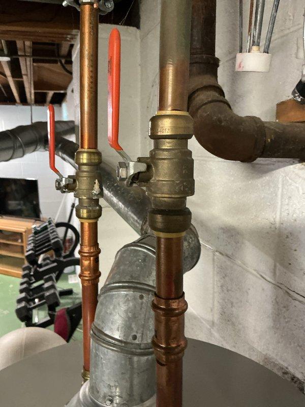 Completed replacement estimate for a 40-gallon natural gas water heater in a 50-year-old residential property. The existing Bradford White automatic storage water heater, with a 40,000 BTU/hr input rating, was assessed and found to have a slight leak requiring replacement. Documented the current installation including copper supply piping with brass ball valves featuring orange handles, compression fittings, and proper shutoff valve configuration. The water heater is located in the basement utility area with exposed concrete block walls and accessible plumbing connections. Photographed existing equipment specifications, piping assembly, and installation conditions to provide accurate replacement recommendations. The current unit shows standard residential plumbing infrastructure with professional-grade components typical of heating and water circulation systems.