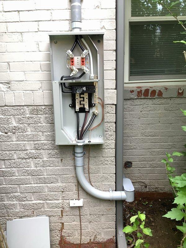 Completed a 200-amp electrical service upgrade with exterior disconnect installation to meet 2023 National Electrical Code requirements. Installed new meter box assembly with dual meter sockets, circuit breaker panel, and gray PVC conduit routing from the exterior meter location into the ground near the foundation. All necessary code updates were implemented, parts were ordered and delivered, and the installation was mounted on the exterior brick wall with proper conduit connections and grounding.