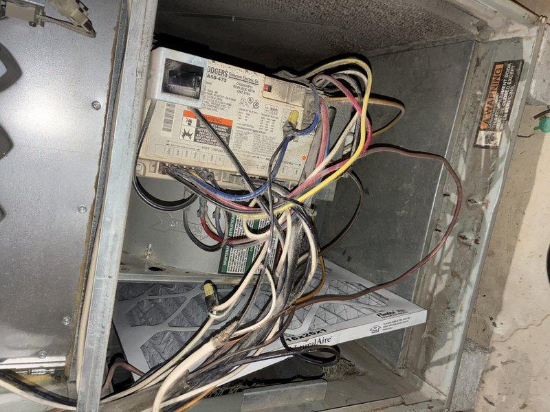 Responded to service call for non-operational air conditioning system. Upon inspection, found 30-year-old unit with extensive dust and debris accumulation on blower motor assembly, fan housing, and internal components. Accessed control panel and examined Rogers control module, verified electrical connections, and assessed overall system condition. Documented heavy buildup throughout blower wheel, motor housing, and mounting hardware indicating prolonged service life and lack of recent maintenance. Given the age of the equipment and condition of internal components, recommended full system replacement as most cost-effective solution rather than investing in repairs to aging unit approaching end of expected service life.
