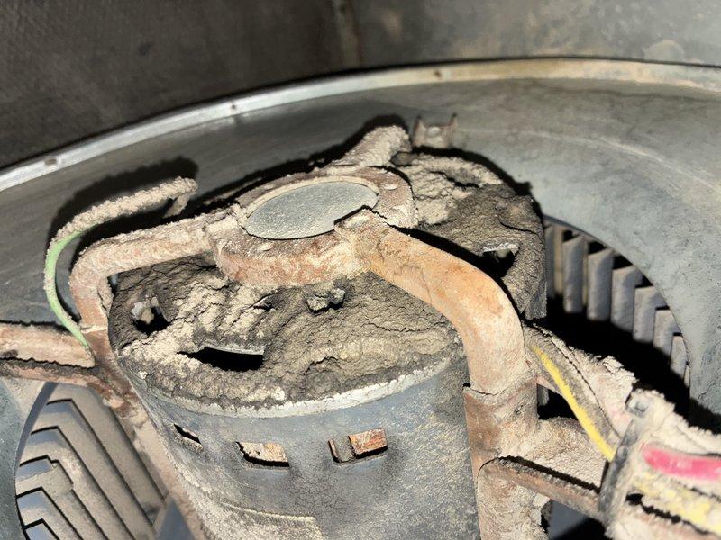 Responded to service call for non-operational air conditioning system. Upon inspection, found 30-year-old unit with extensive dust and debris accumulation on blower motor assembly, fan housing, and internal components. Accessed control panel and examined Rogers control module, verified electrical connections, and assessed overall system condition. Documented heavy buildup throughout blower wheel, motor housing, and mounting hardware indicating prolonged service life and lack of recent maintenance. Given the age of the equipment and condition of internal components, recommended full system replacement as most cost-effective solution rather than investing in repairs to aging unit approaching end of expected service life.
