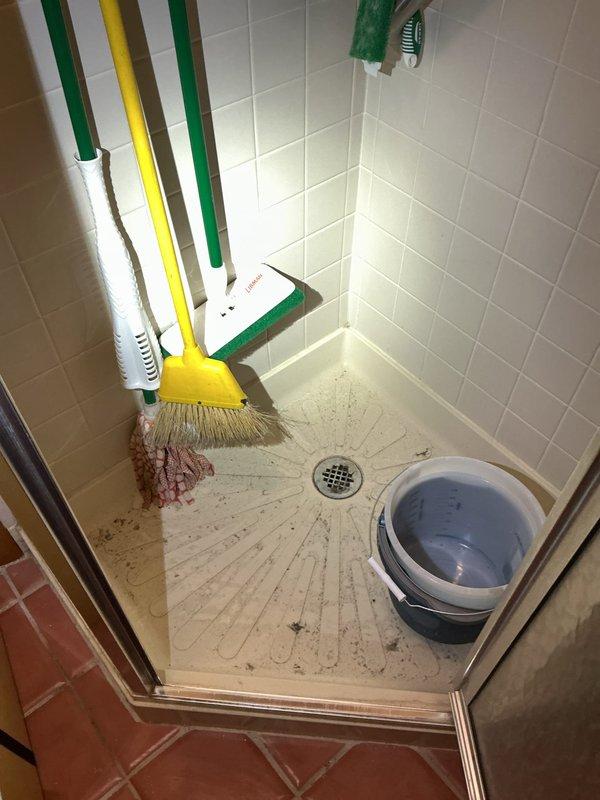 Responded to washing machine drainage issue causing water backup into adjacent shower stall in 1955-era home. Upon arrival, assessed the plumbing configuration and determined the washing machine discharge line was improperly draining into the shared drain system, creating hydraulic pressure that forced water through the shower drain during wash cycles. Inspected the drain line routing and confirmed inadequate venting or partial blockage in the common waste line serving both fixtures. Cleared the drainage pathway to restore proper flow and eliminate the backup condition. Verified successful operation by running test cycles and confirming no further water discharge into the shower area.