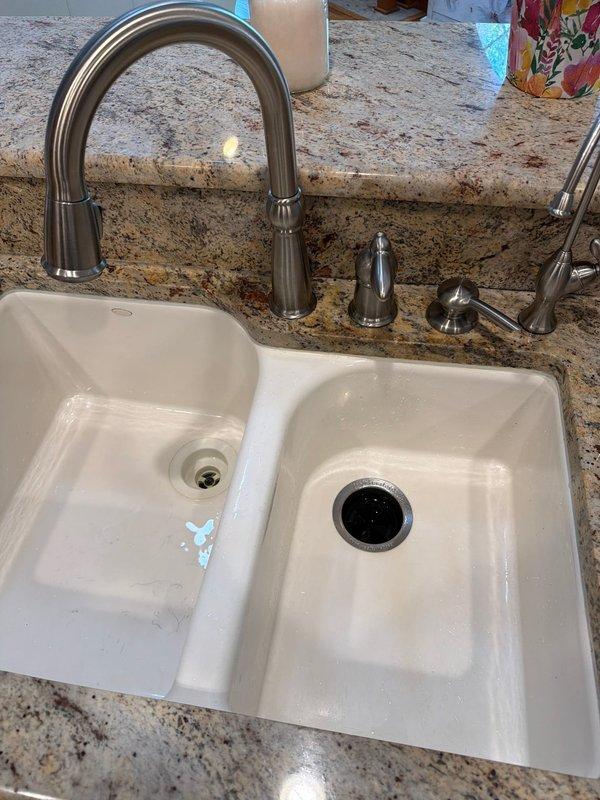 Responded to service call for multiple plumbing fixtures requiring attention. Inspected kitchen faucet with sensitivity issues causing intermittent leaking when nozzle positioning was not precise, evaluated second-floor bathroom sink faucet with slow drip condition, and assessed toilet tank components requiring replacement. Documented all fixtures with photographic evidence showing double-basin kitchen sink with pull-down faucet assembly and toilet tank interior with worn flush mechanism components for replacement recommendations.