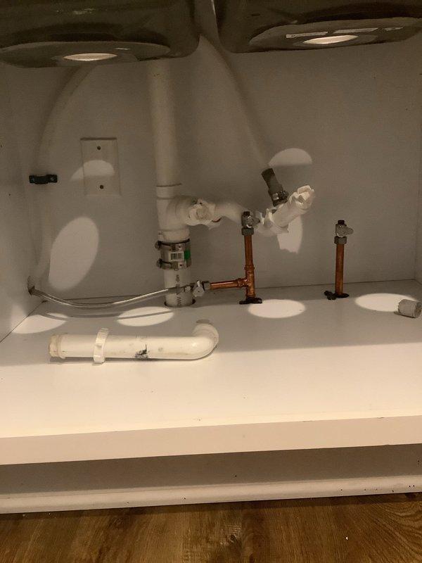 Completed installation and hookup of bathroom sink faucet in double-basin vanity. Connected water supply lines to faucet assembly, installed P-trap drainage system with proper venting, and verified all connections for leaks. All plumbing components are functioning properly with no visible leaks detected upon testing.