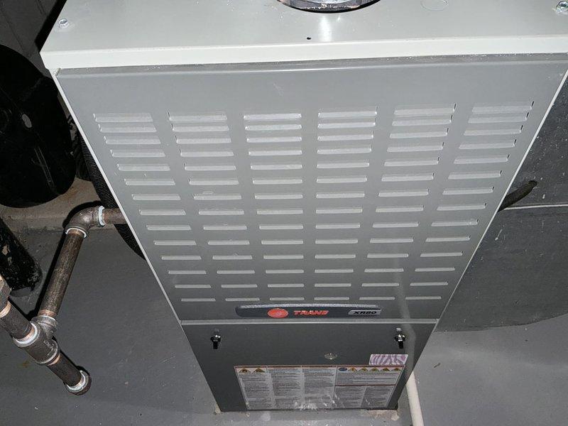 Conducted comprehensive assessment of existing Trane furnace and air conditioning system for replacement estimate. Documented current equipment condition, including furnace unit with operational ventilation louvers, associated ductwork, gas line connections, and aged copper piping showing normal wear. Customer requested competitive pricing comparison for complete HVAC system replacement.