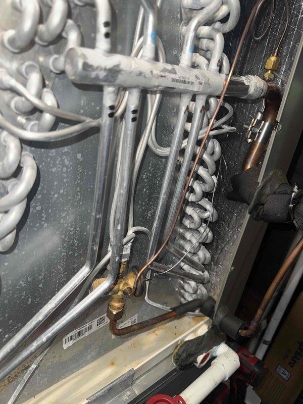 # HVAC Maintenance - Cooling

Completed MVP cooling maintenance visit on 3-year-old system. Upon inspection, discovered significant frost and ice accumulation on evaporator coil assembly and mounting surfaces, indicating potential airflow restriction or refrigerant charge issues. Documented system conditions including serpentine coil configuration, copper refrigerant lines with brass fittings, and electrical connections. Inspected control board assembly featuring DIP switch configurations and electronic components to verify proper system operation and settings.

System requires follow-up attention to address icing condition, which may stem from restricted airflow, low refrigerant charge, or metering device malfunction. Photographed equipment for service records and further diagnostic evaluation.