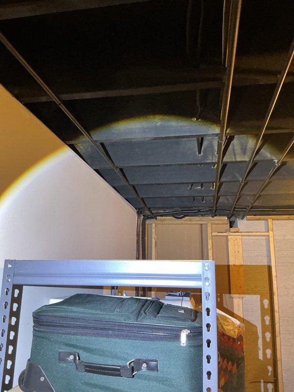 Responded to request for plumbing reroute in basement area to accommodate kitchen sink and laundry connections. Upon arrival, assessed existing pipe configuration and determined optimal routing path for water supply and drain lines. Installed protective plastic sheeting and containment barriers in work area to prevent damage to stored items and maintain clean workspace during pipe installation. Rerouted plumbing lines through basement ceiling joists to new locations as specified, ensuring proper slope for drainage and adequate support for water supply lines. Work completed successfully with all connections properly secured and tested for leaks.