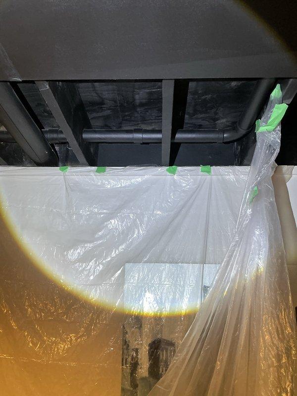 Responded to request for plumbing reroute in basement area to accommodate kitchen sink and laundry connections. Upon arrival, assessed existing pipe configuration and determined optimal routing path for water supply and drain lines. Installed protective plastic sheeting and containment barriers in work area to prevent damage to stored items and maintain clean workspace during pipe installation. Rerouted plumbing lines through basement ceiling joists to new locations as specified, ensuring proper slope for drainage and adequate support for water supply lines. Work completed successfully with all connections properly secured and tested for leaks.
