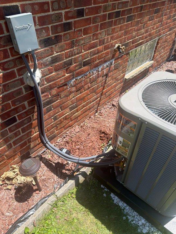 Completed full HVAC system replacement including installation of Lennox Elite EL280E 70,000 BTU two-stage gas furnace, 2-ton air conditioning condenser with matching evaporator coil utilizing R-454B refrigerant, new programmable thermostat, and media air filtration system. Installed outdoor disconnect with 20-amp Littelfuse fuse protection and gray electrical conduit from junction box to condenser unit mounted on concrete pad against exterior brick wall. System commissioned and tested for proper operation with all electrical connections verified, refrigerant charge confirmed to manufacturer specifications, and airflow balanced throughout distribution system.