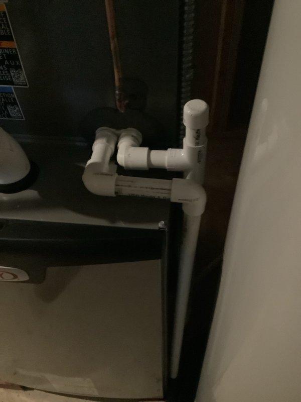 Completed installation of a 90% efficiency furnace and air conditioning system in basement location. Installed new air handler unit suspended from ceiling joists with proper support, connected to new ductwork system including large-diameter supply trunk lines. Configured PVC condensate drainage system with multiple elbows and joints to route condensate away from equipment according to code requirements. Ran white PVC venting pipes from furnace through building structure for proper combustion air intake and exhaust. Installed all necessary electrical connections and control wiring to air handler and outdoor condensing unit. System tested and verified operational with proper airflow and drainage confirmed.