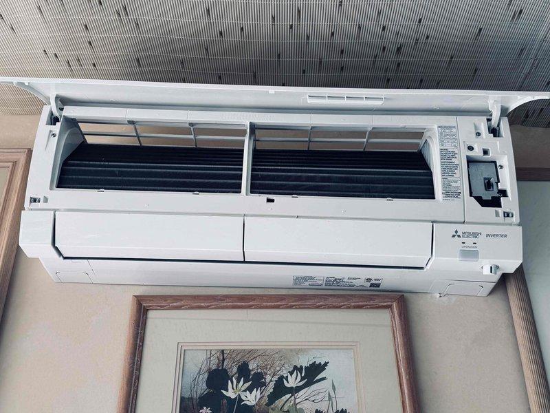 Responded to service call regarding brown substance discharging from air conditioning unit fins. Upon arrival, inspected wall-mounted Mitsubishi Electric inverter split system. Opened front access panel to examine internal components, evaporator coil assembly, and blower wheel sections. Documented unit condition with photographs showing evaporator coils, internal deflector fins, and blower fans for diagnostic purposes and service records.