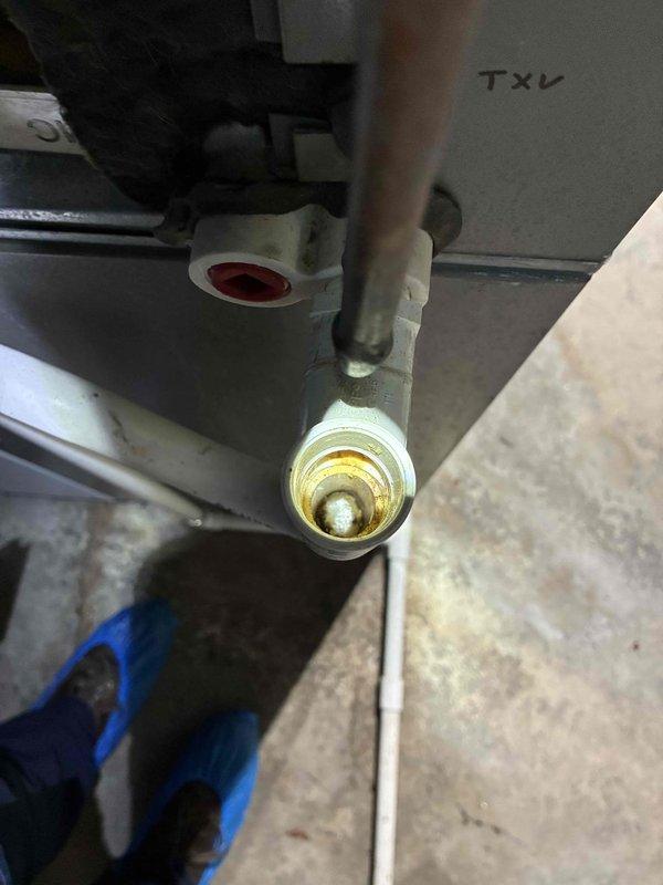 Completed MVP cooling maintenance visit on 7-year-old system. Inspected refrigerant line connections and TXV assembly, confirming proper threading and mechanical integrity. Documented significant dirt and debris accumulation on evaporator coil fins with visible vertical staining patterns indicating restricted airflow. Coil shows moderate contamination requiring attention to maintain optimal heat transfer efficiency and system performance.