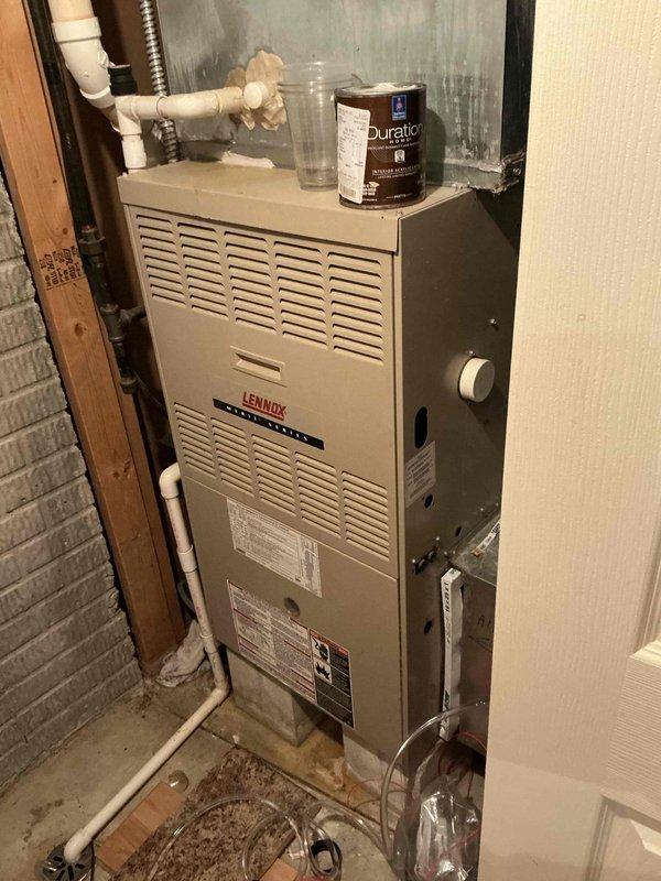 Conducted comprehensive on-site evaluation for complete HVAC system replacement at residential property. Assessed existing 23-year-old Lennox furnace unit currently installed in basement utility area, documenting equipment condition, installation configuration, and surrounding infrastructure including PVC condensate drainage lines, ductwork connections, and electrical service. Photographed current system layout to support replacement proposal development for whole-house heating and cooling equipment upgrade.