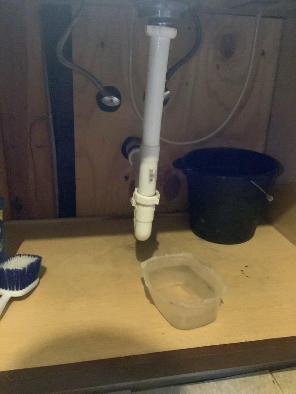 Responded to service call for leaking kitchen and bathroom sinks sharing a common wall. Upon arrival, performed diagnostic inspection of both drain assemblies and identified defective P-trap connections and deteriorated drain fittings causing water leakage beneath both fixtures. Contacted customer to review repair options and received authorization to proceed. Replaced white PVC drain pipe assemblies including P-traps, tailpieces, and connecting fittings for both kitchen and bathroom sinks. Tested all connections for proper drainage and verified leak-free operation. Documented completed installation with photographs showing new plumbing configuration and cleared work area.